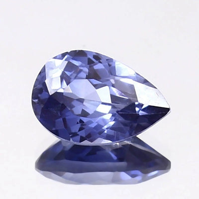 Faceted Kashmir Sapphire gemstone on a light gray background