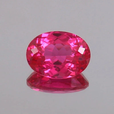 Faceted Ceylon Pink Sapphire gemstone on a gray background