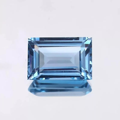blue Aquamarine gemstone on a light gray background
