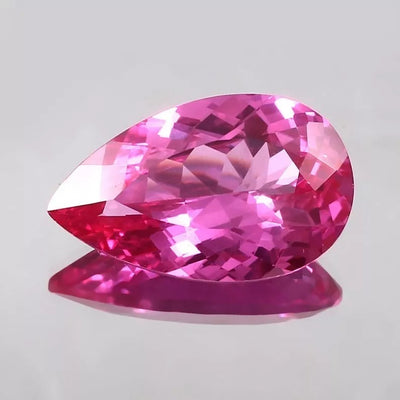 Pear-shaped Flawless Ceylon Pink Sapphire gemstone on a light gray background