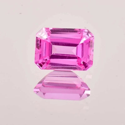 Pink Ceylon Sapphire gemstones on a light gray background