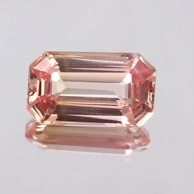 Peach Ceylon Padparadscha Sapphire gemstone on a light gray background