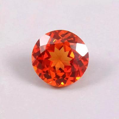 Round Orange Sapphire gemstone on a light gray background