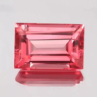 Padparadscha Sapphire – Baguette Cut gemstone on a light gray background