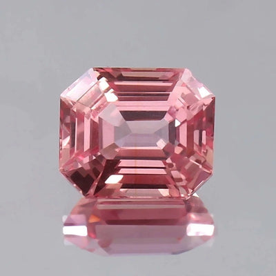 Pink Padparadscha Sapphire gemstone with a clear gray background