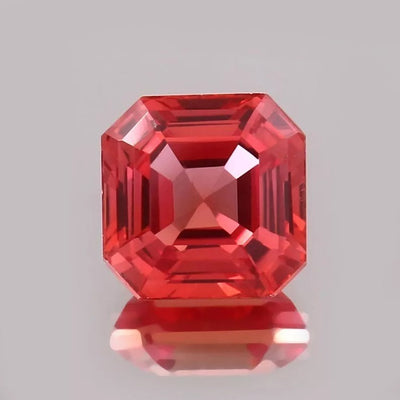 Padparadscha Sapphire gemstone with a clear gray background