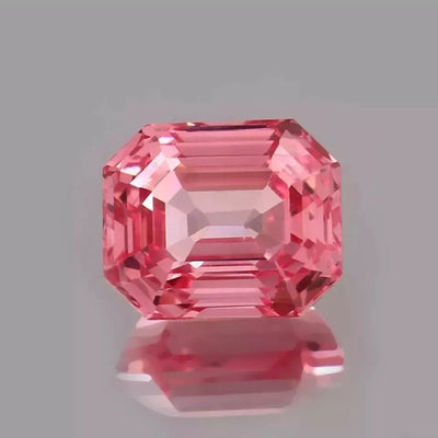Padparadscha Sapphire gemstone on a gray background