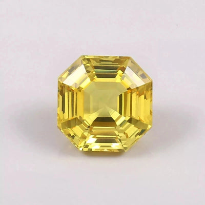 Yellow Sapphire asscher gemstone with a geometric cut on a light pink background