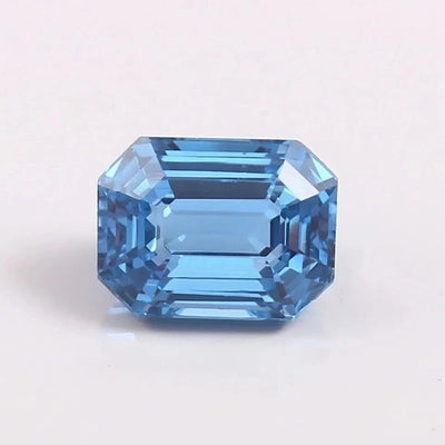 Faceted blue Aquamarine gemstone on a light gray background