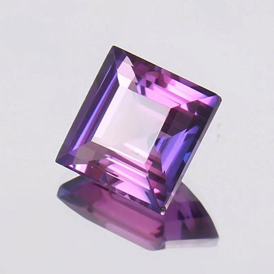 Square-cut Purple Pink Ceylon Sapphire gemstone on a light gray background