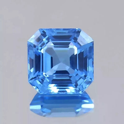 Faceted Ceylon Blue Spinel gemstone on a gray background